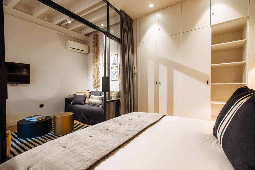 dormitorio con cerramiento de vidrio y metal decorado con fibras y madera