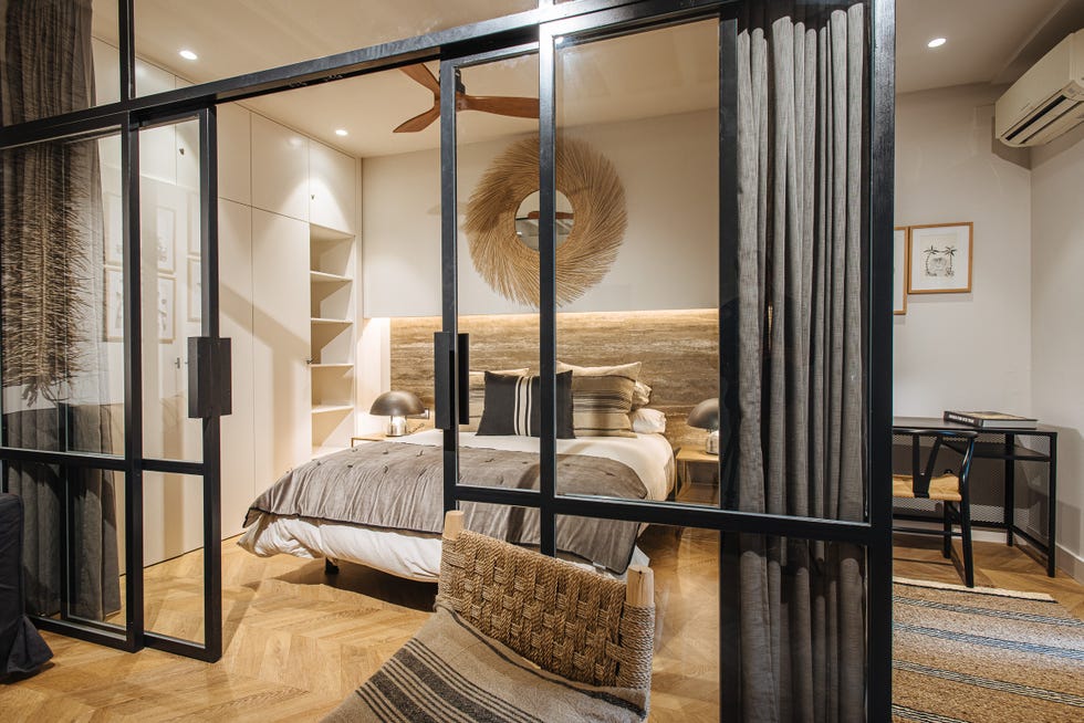 dormitorio con cerramiento de vidrio y metal decorado con fibras y madera