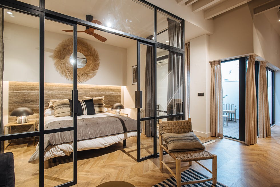 dormitorio con cerramiento de vidrio y metal decorado con fibras y madera