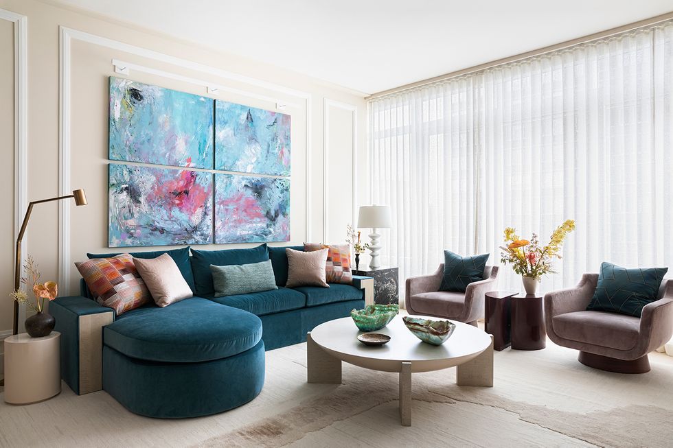 salón con muebles de diseño, sofá con chaise longue de terciopelo azul y dos butacas
