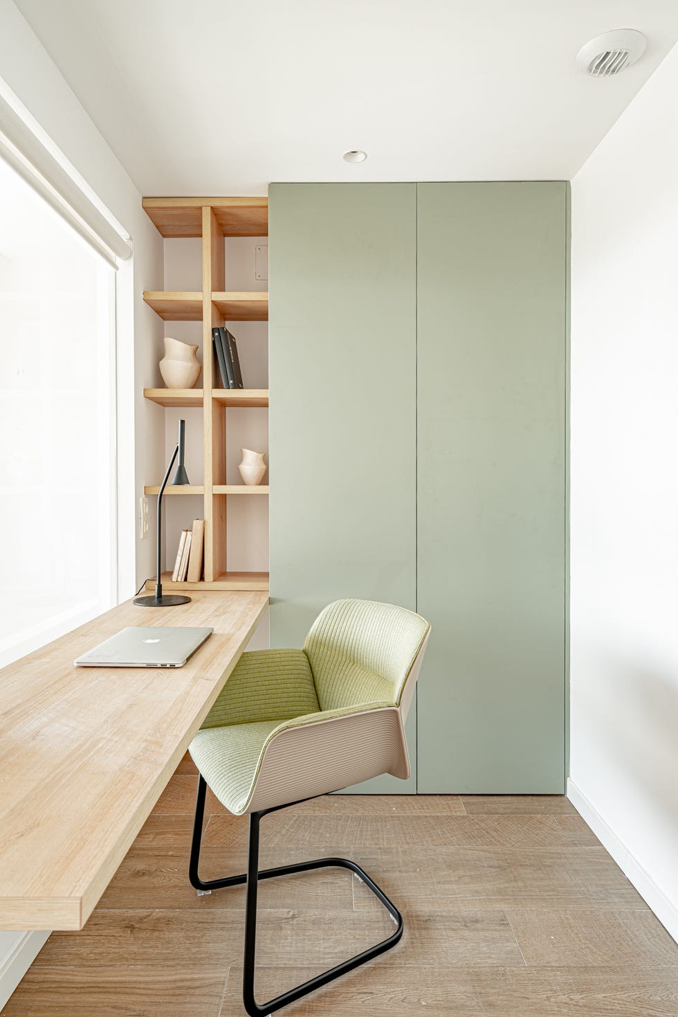 despacho con escritorio volado de madera y armario con puertas verdes