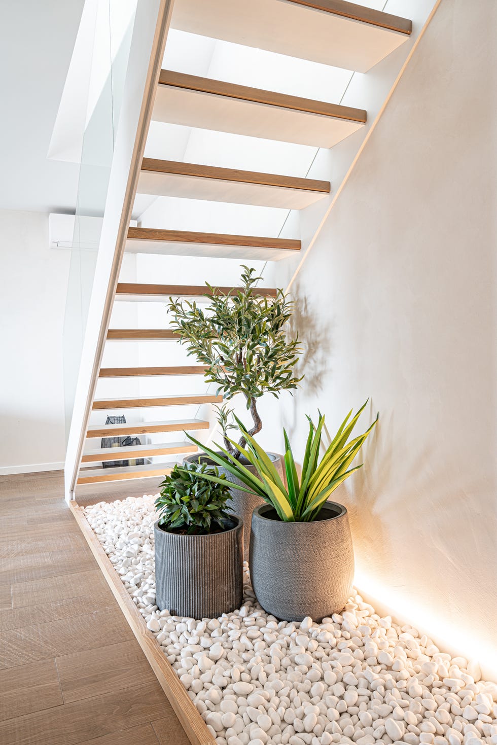 hueco de la escalera decorado con piedras y plantas
