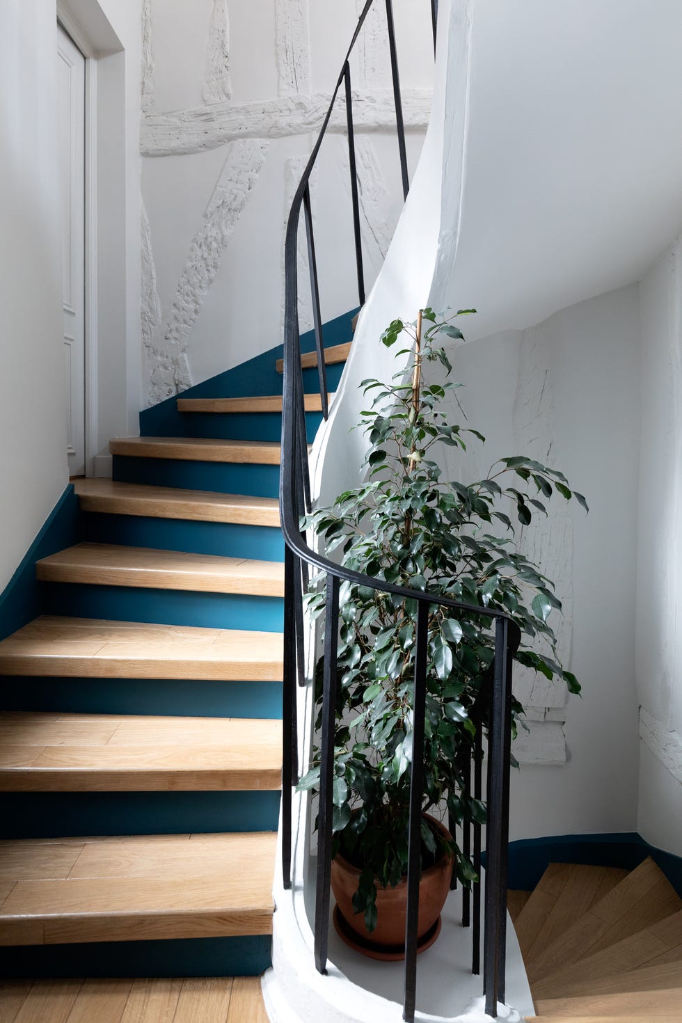 escalera con peldaños de madera y barandilla de forja negra