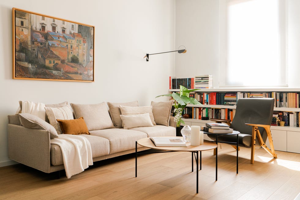 salón decorado en tonos neutros con librería baja