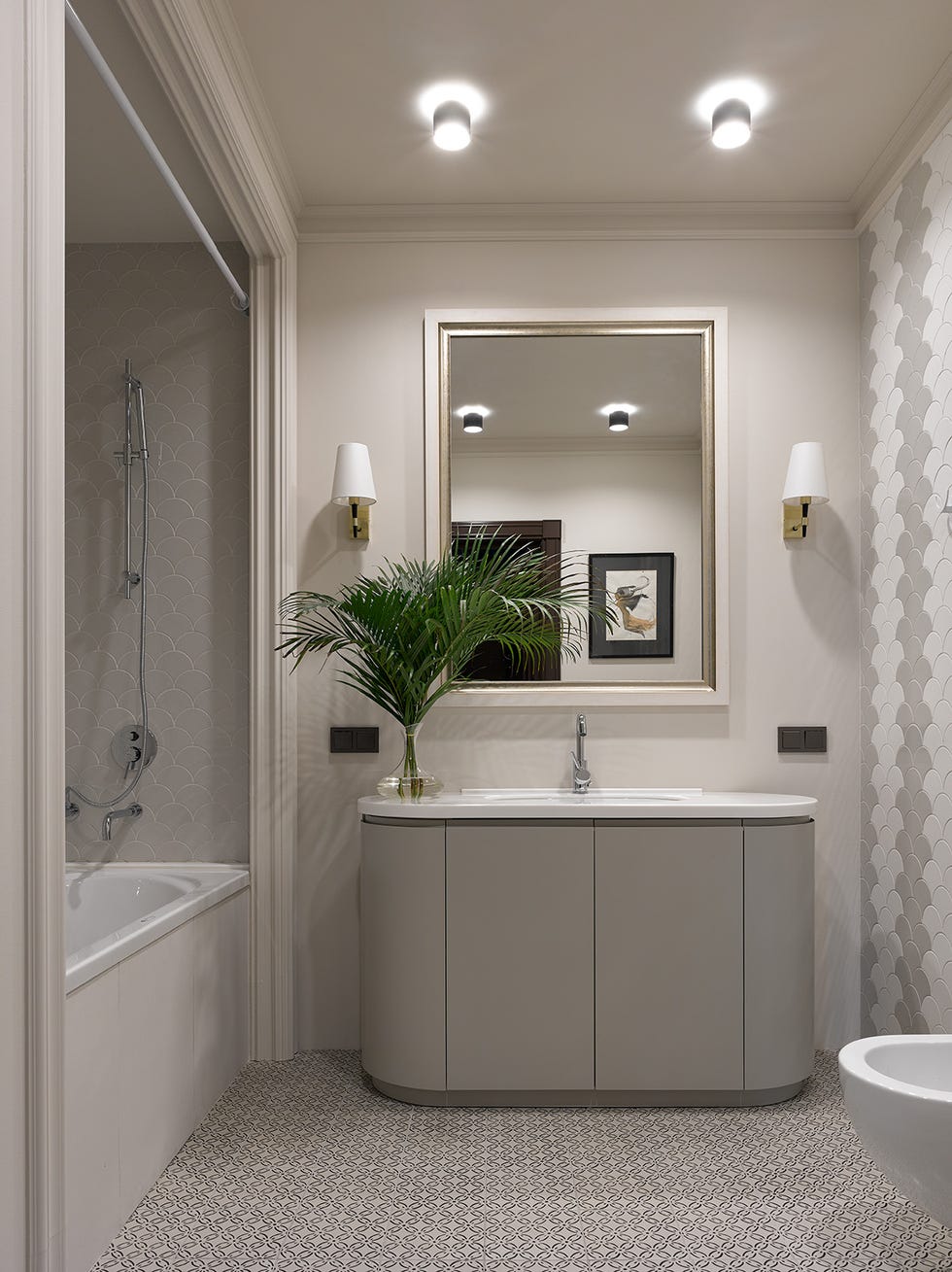 baño con bañera y azulejos de escama en tonos blancos y grises