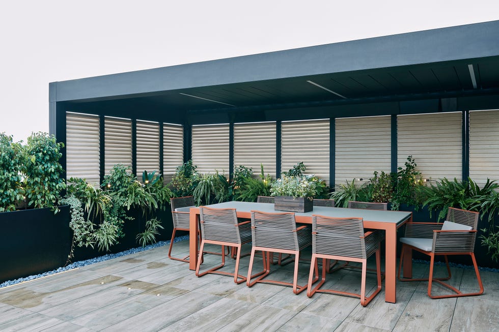 terraza con pérgola y mesa de comedor
