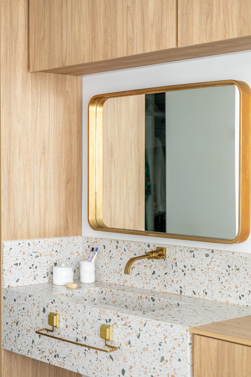lavabo de terrazo y grifería dorada