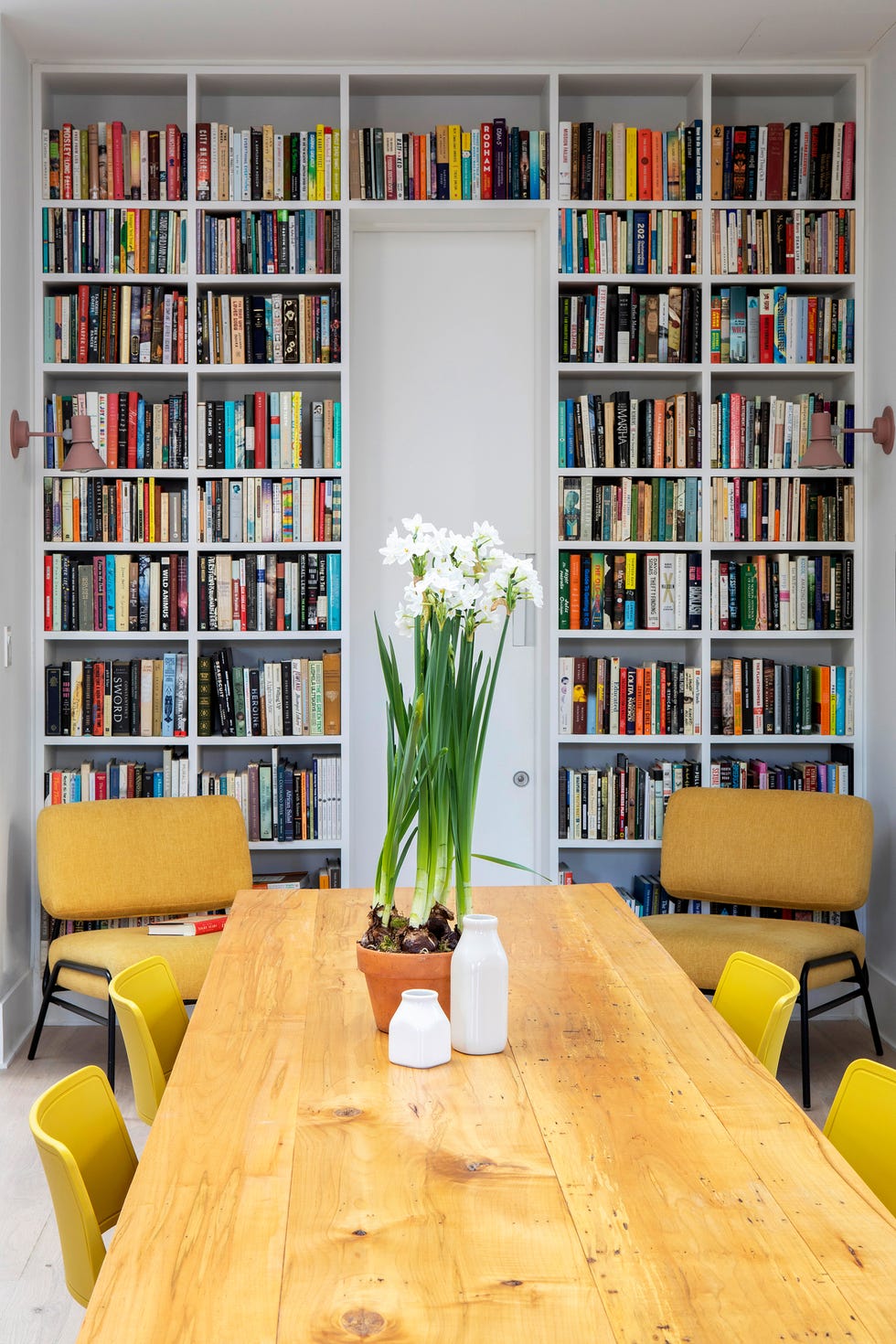 biblioteca con dos butacas de color mostaza junto al comedor