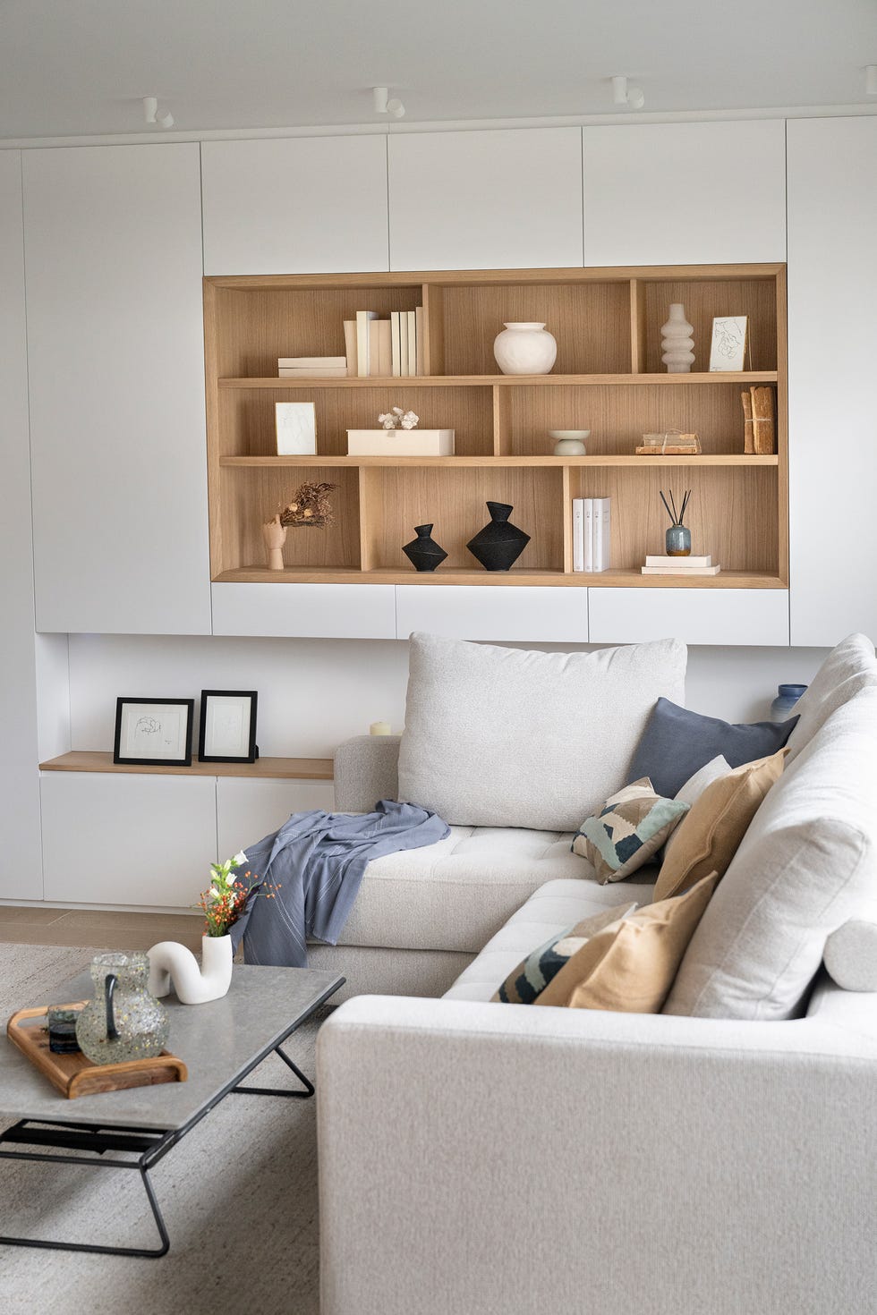 salón con mueble a medida en color blanco con estantería abierta en madera