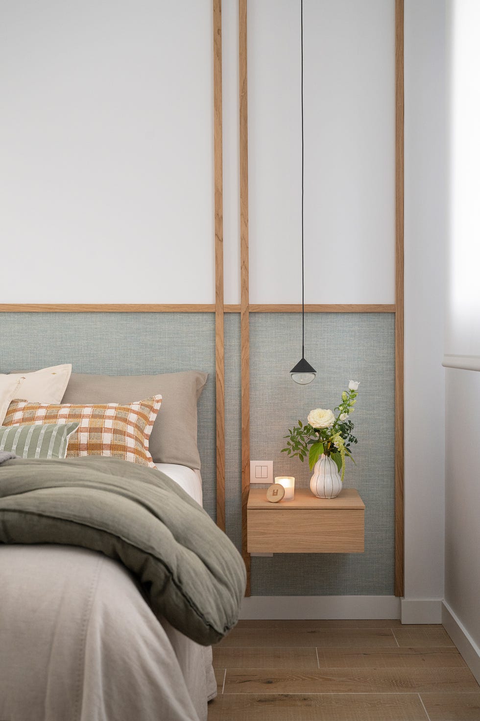 dormitorio con cabecero hecho con listones de madera y mesillas voladas