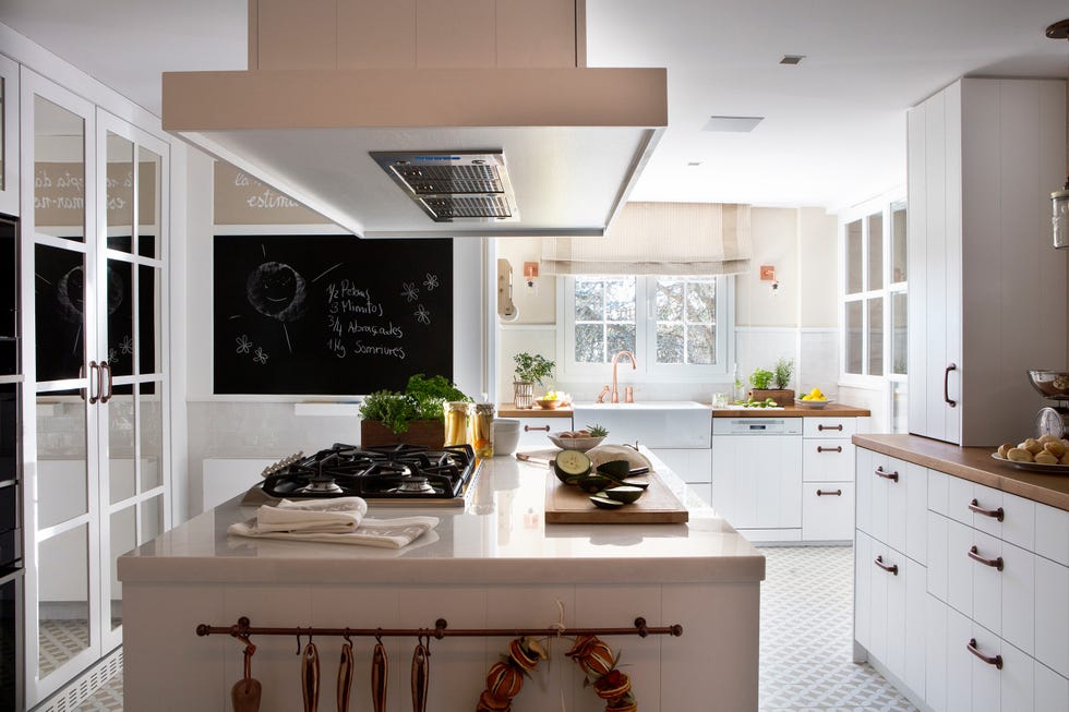 cocina con isla central diseñada en blanco con estilo rústico