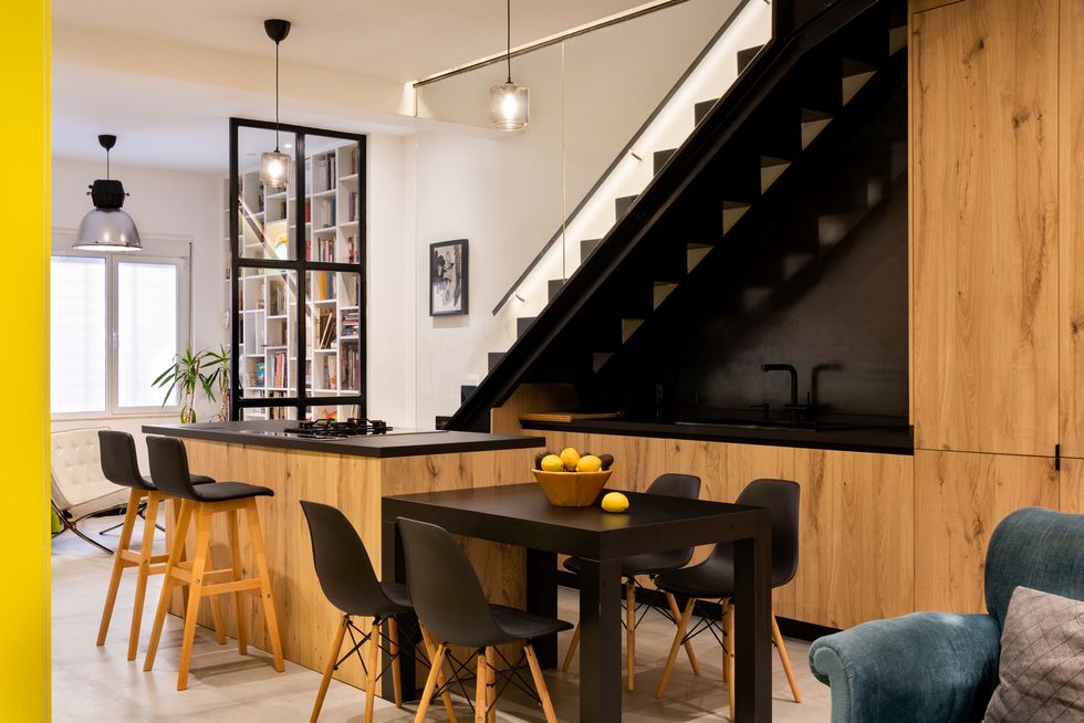 Cocina con office de estilo industrial decorada en color negro con madera