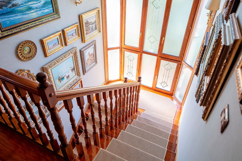 escaleras de madera con cuadros en las paredes