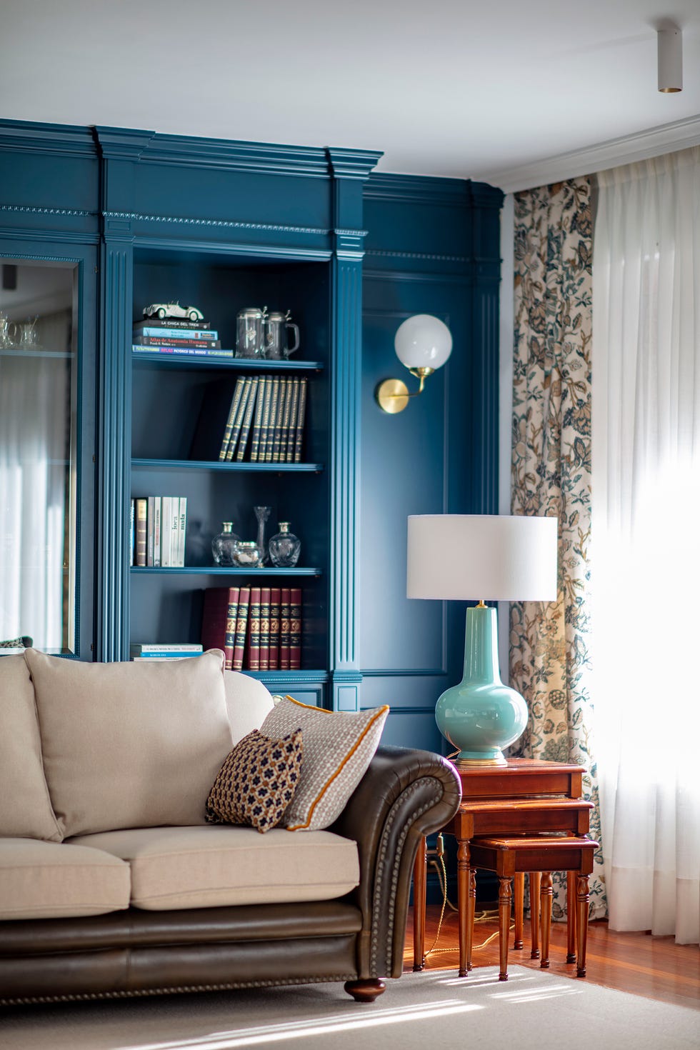 salón clásico con sofá chester y librería azul