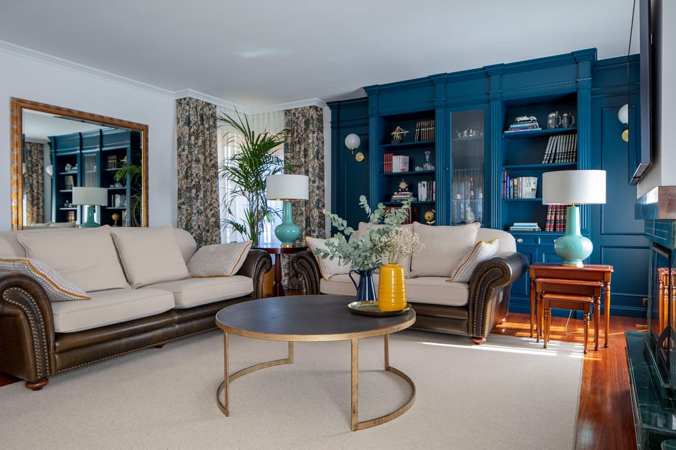 salón clásico con sofás chester y librería azul