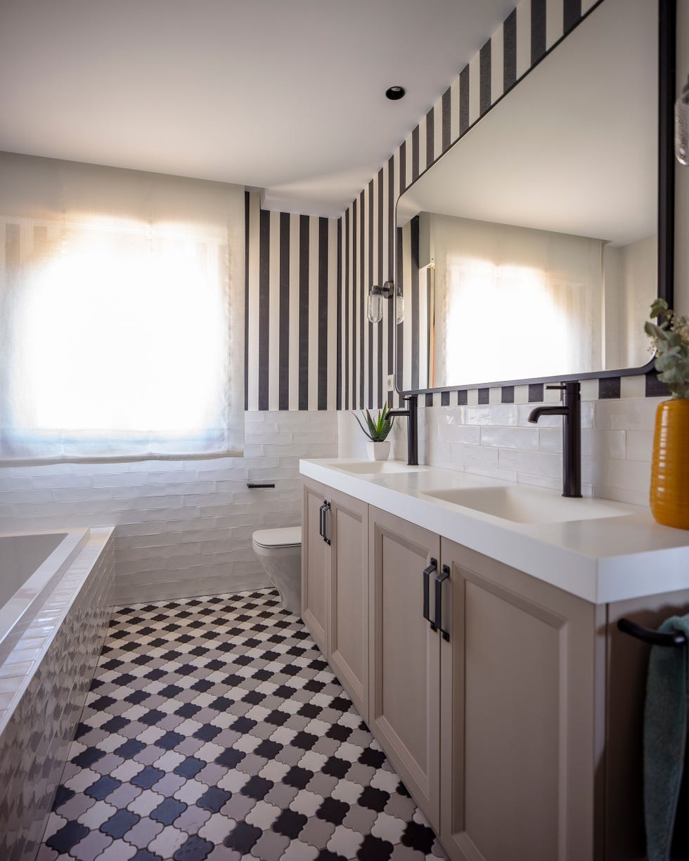 baño con mueble en color visón y papel pintado a rayas en las paredes