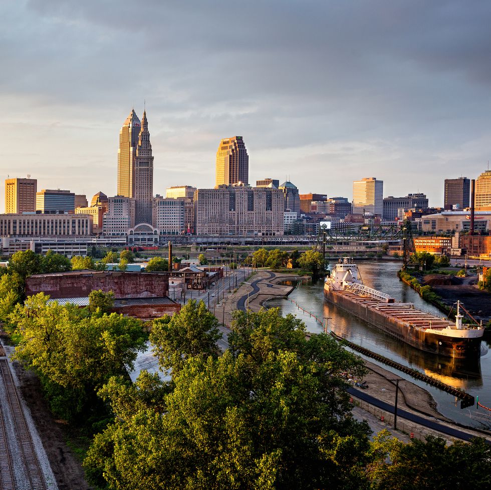 dusk skyline of downtown cleveland ohio with freighter on the cuyahoga river