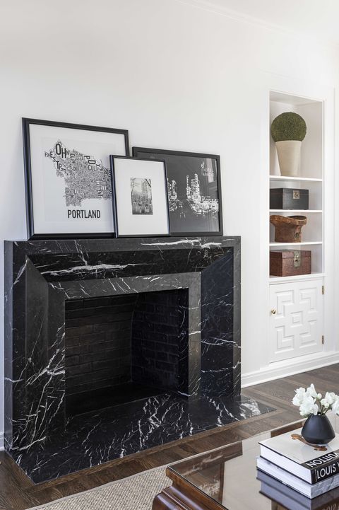 marble fireplace, living room, stacks of coffee table books, coffee table, wall art