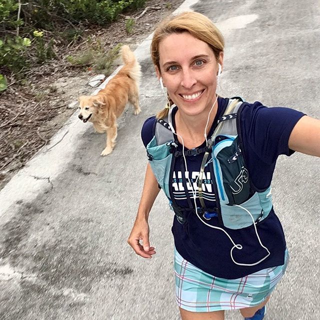 jen golbeck smiling while running with a dog behind them