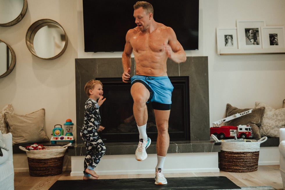 a man exercising indoors while a child watches