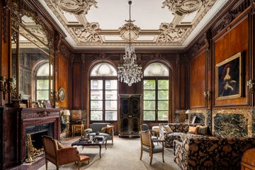 gilded age mansion interiors with chandeliers, ornate crown moldings, mirrored mantel, and more