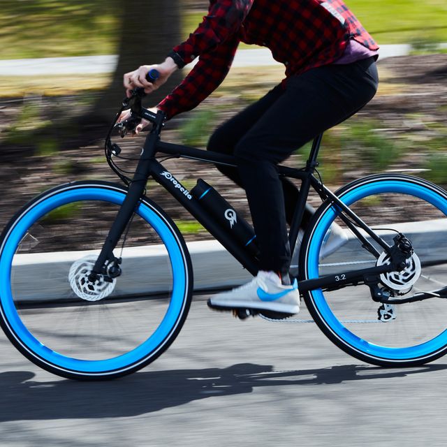 person riding an ebike with blue wheels