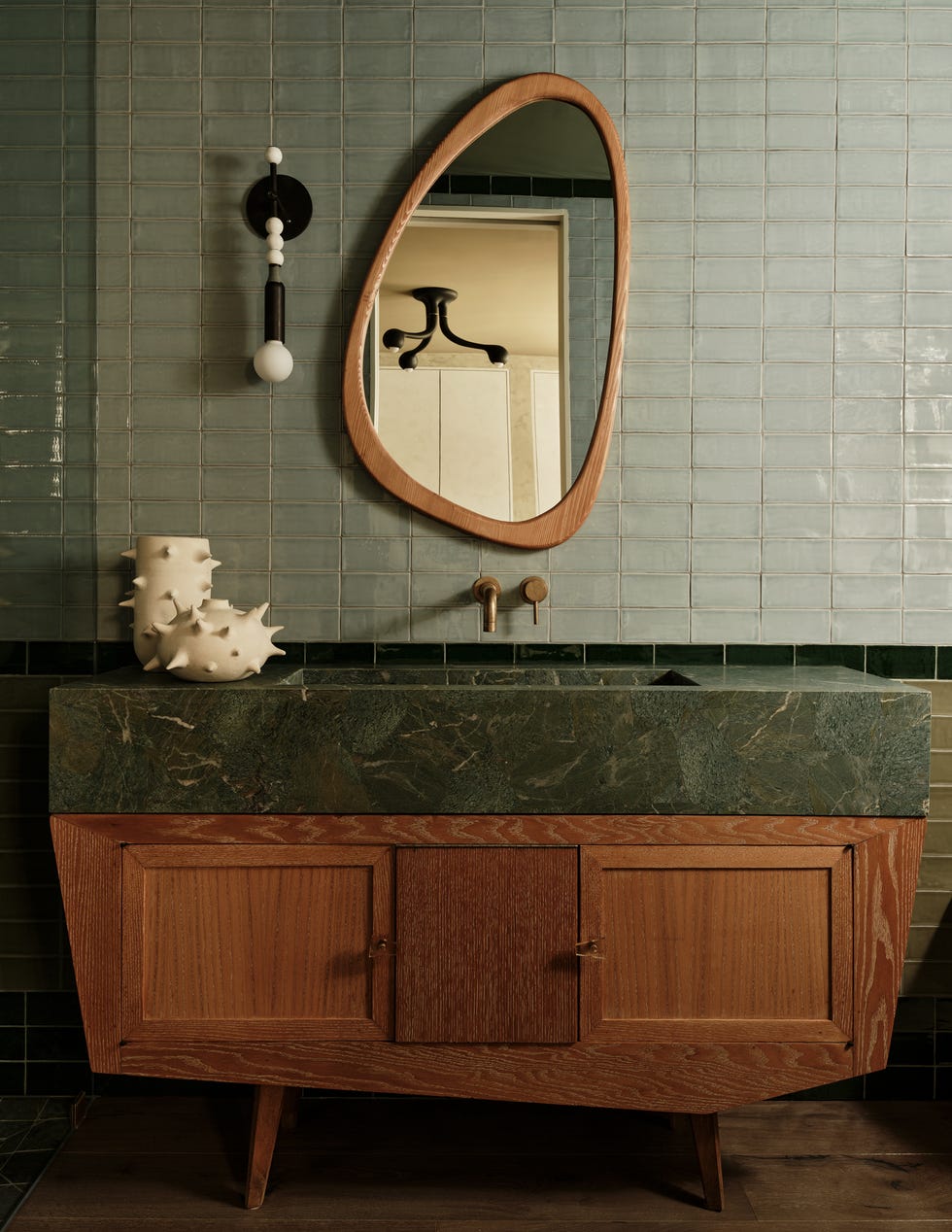 Vintage-style bathroom vanity with a green marble top and a feature mirror.
