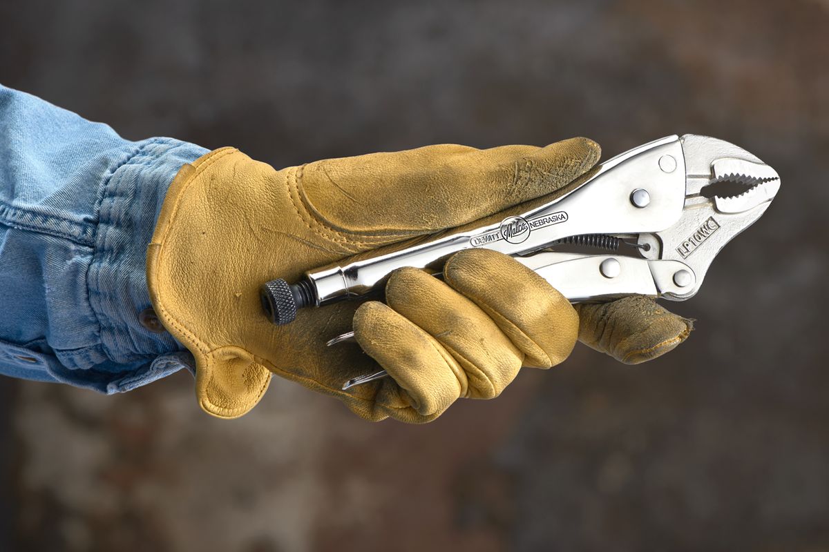 hand in work glove holding eagle grip locking pliers