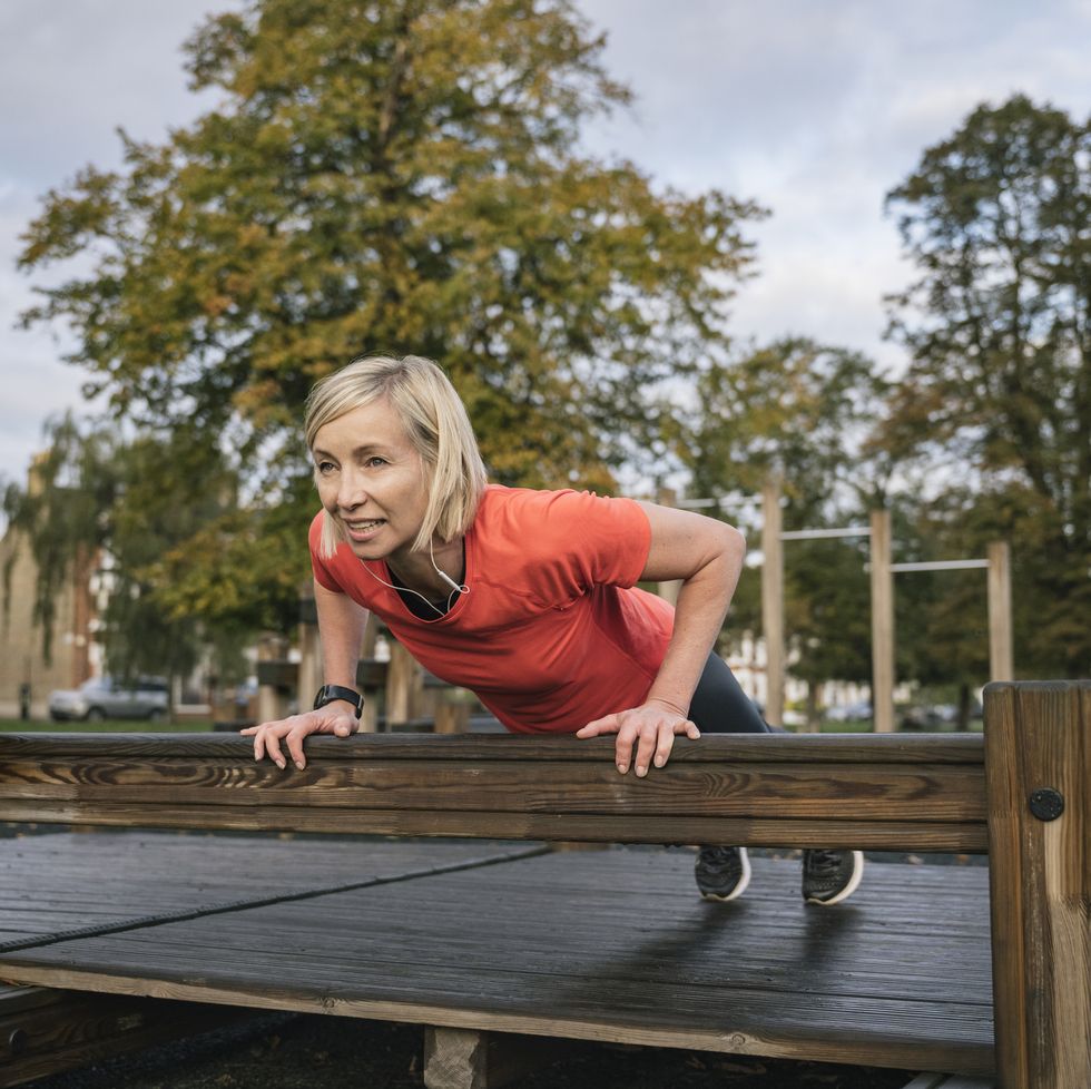 early 50s female athlete doing incline push ups outdoors