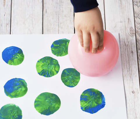 earth day crafts, hand holding a pink balloon with paint on it