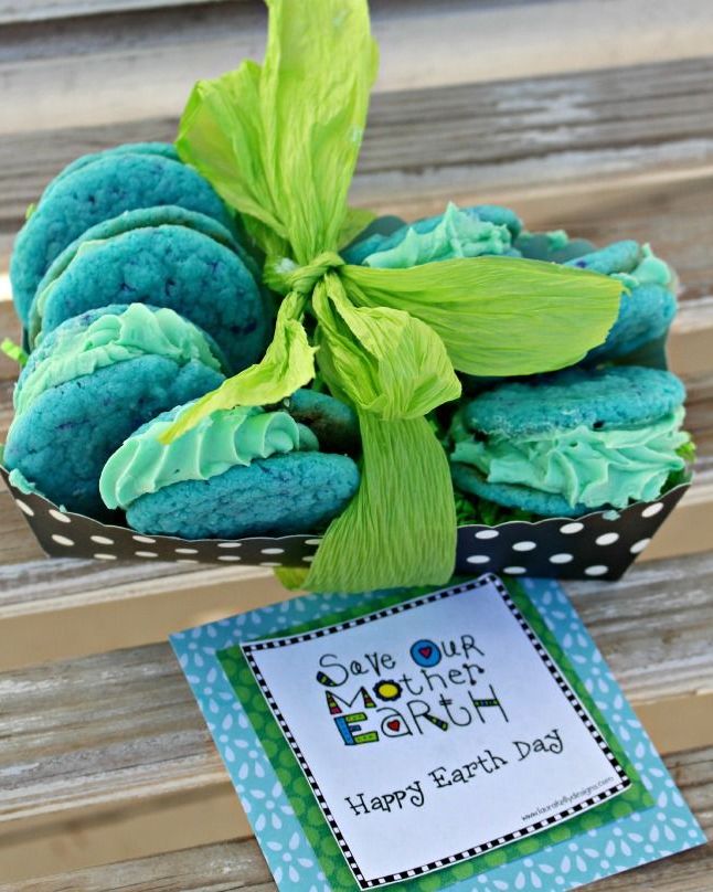 blue sandwich cookies in a paper dish tied with a green ribbon and a tag that reads save our mother earth happy earth day