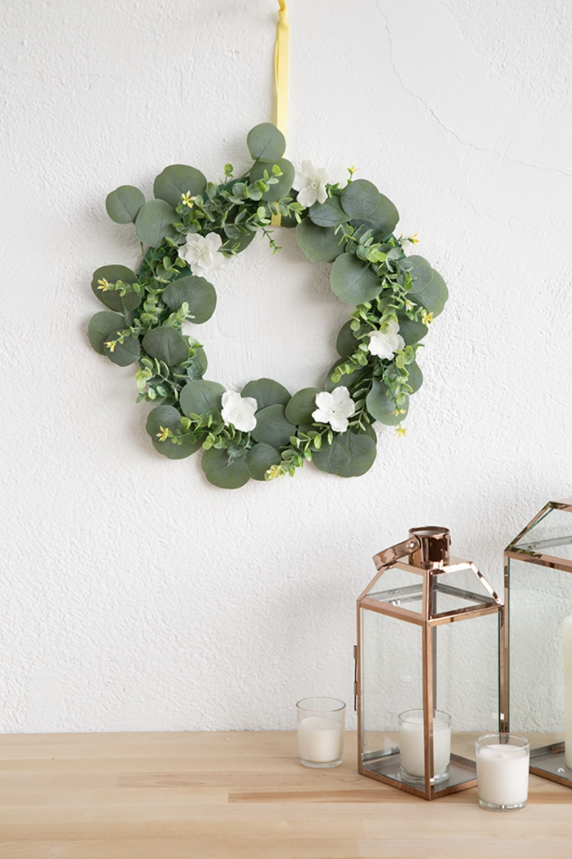 Earth Day crafts, fake green garland hanging on white wall
