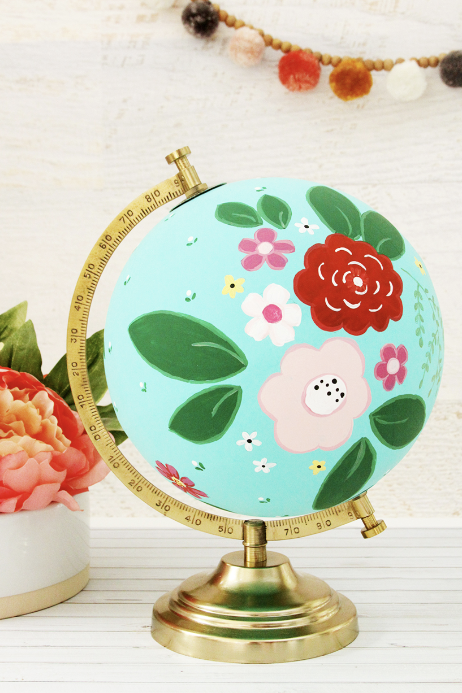 Earth Day crafts, a globe with a floral pattern on a table next to a small white vase