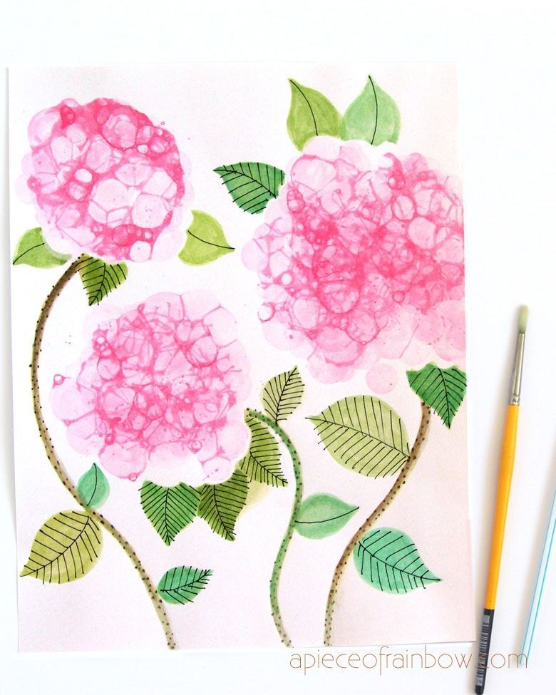 painting of pink hydrangea blossoms with green leaves with a straw and a fine tipped paint brush next to it