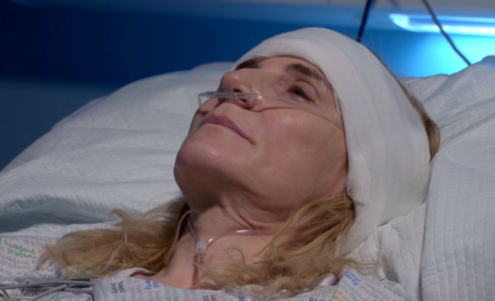 cindy beale in eastenders, a woman lies in a hospital bed with a bandage around her head