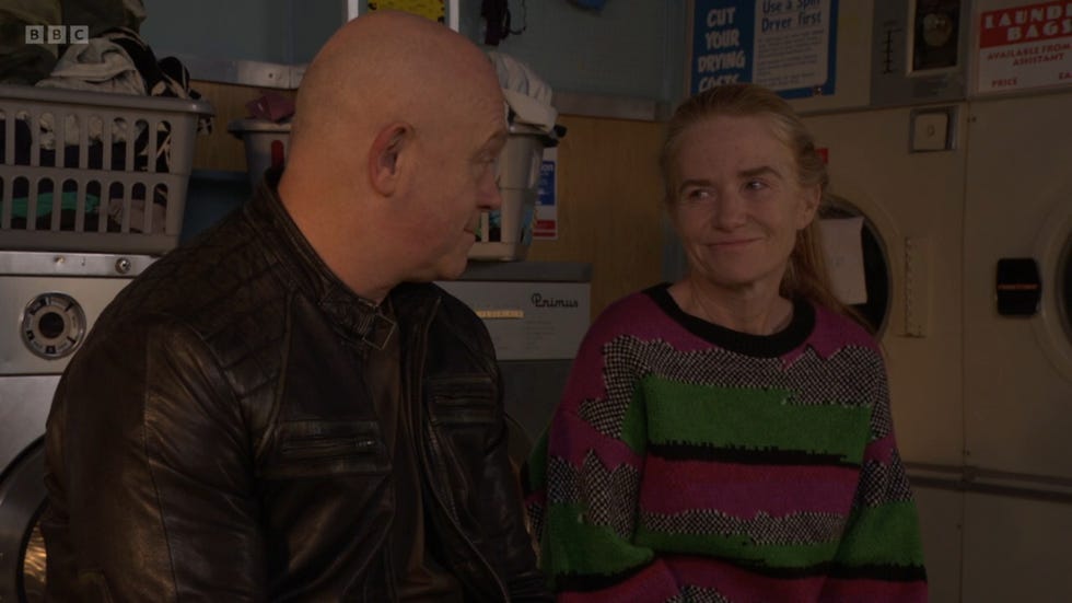 eastenders, grant and bianca sitting in the laundrette, sharing a smile