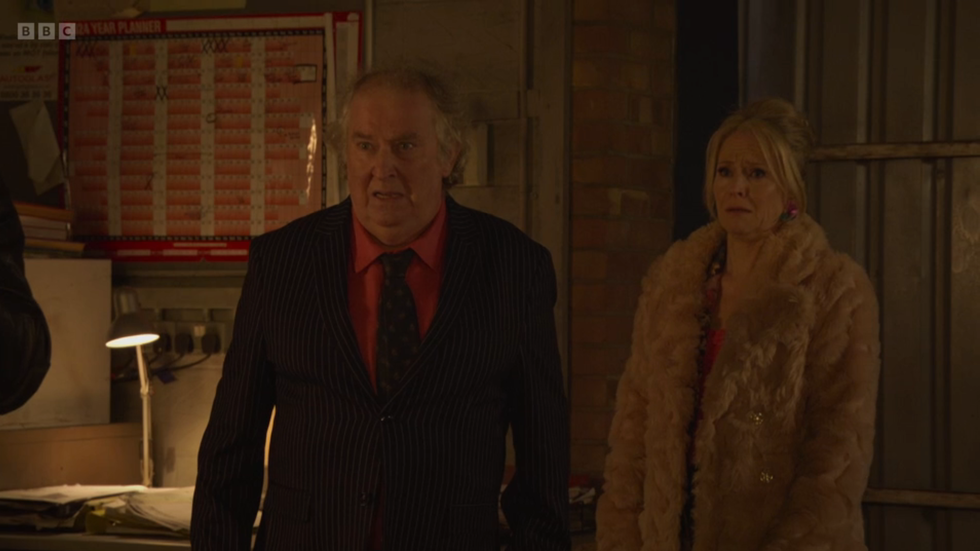 eastenders, nigel bates and linda carter watching on scared at phil with a gun