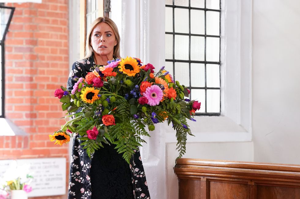 eastenders patsy kensit as emma harding at lola's funeral with a large bouquet of flowers