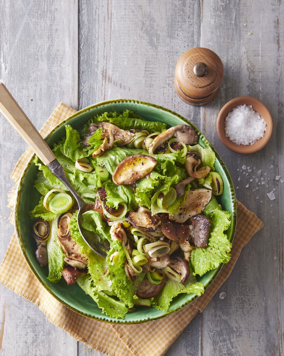 recipes leek mushroom and escarole salad in a large green bowl with a spoon for serving