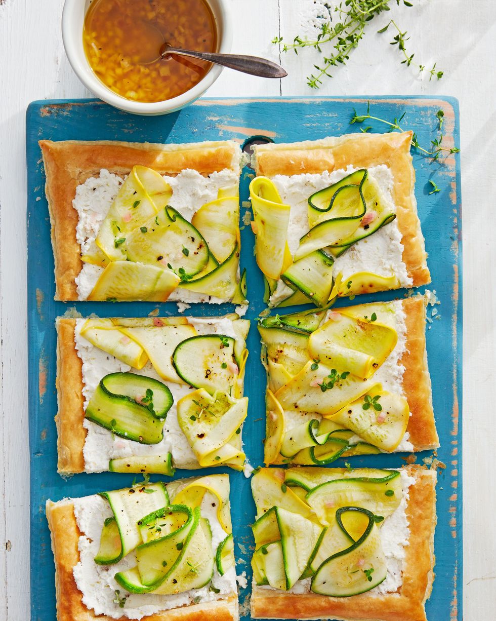 marinated squash tart cut into six pieces and arranged on a blue wooden serving board