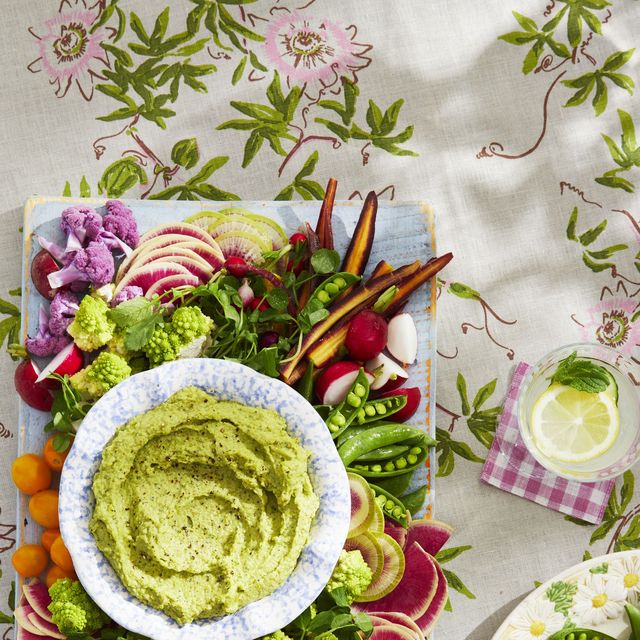 spring crudites board with white bean and pea dip in a bowl in the middle