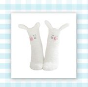white fuzzy socks with bunny ears and fact at top and apple airtag encased in blue silicone holder
