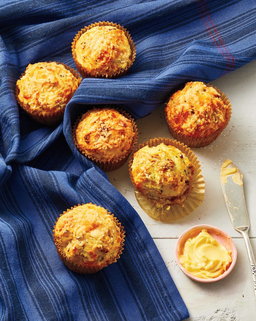 cheddar bacon muffins with a small bowl of butter and a butter knife for serving