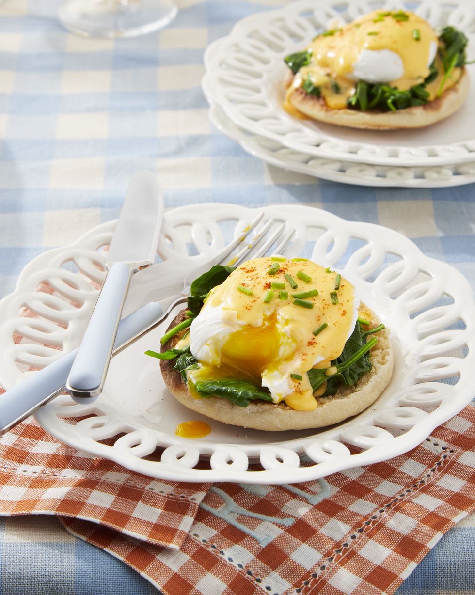 eggs florentine with homemade hollandaise on a white plate with a fork and knife