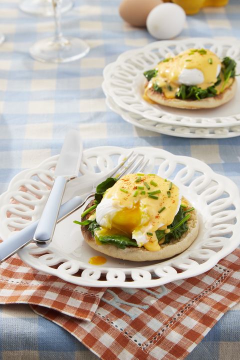 eggs florentine with homemade hollandaise on a white plate with a fork and knife