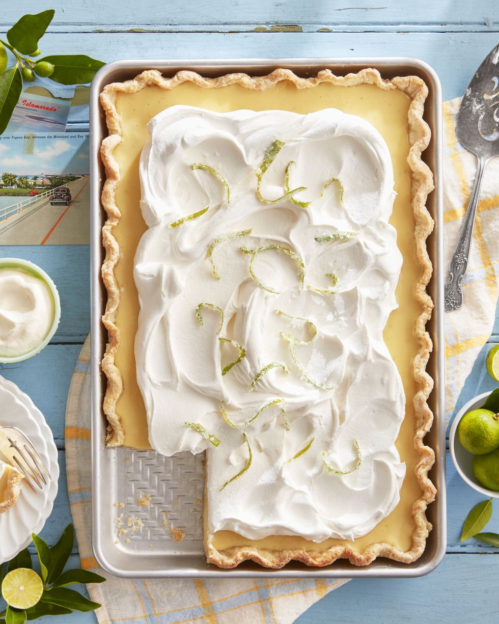 key lime slab pie with candied lime zest in a sheet pan with whipped cream on top