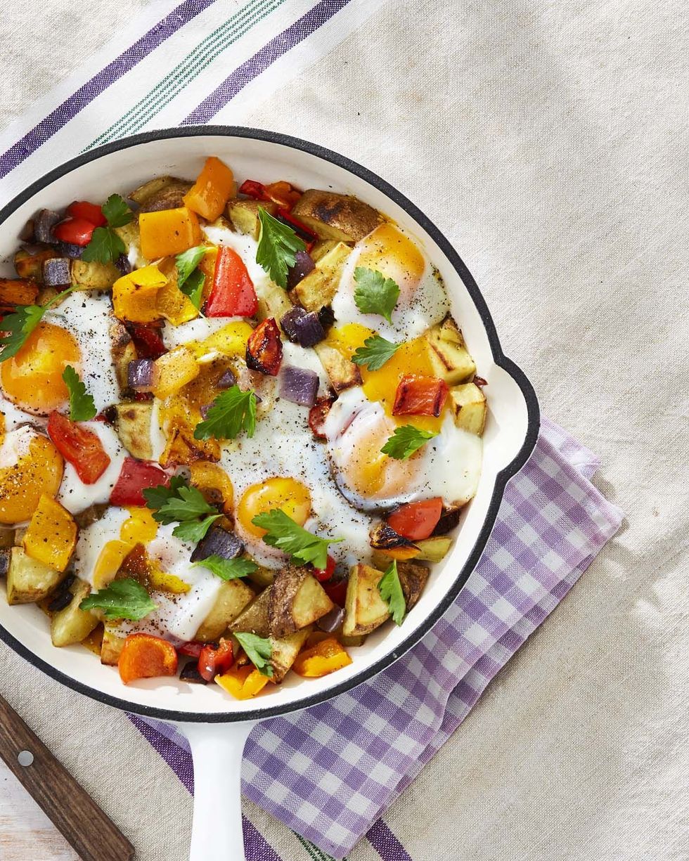 roasted potato and pepper hash in a white enamel cast iron skillet