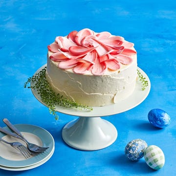 white frosted cake with pink petals on top