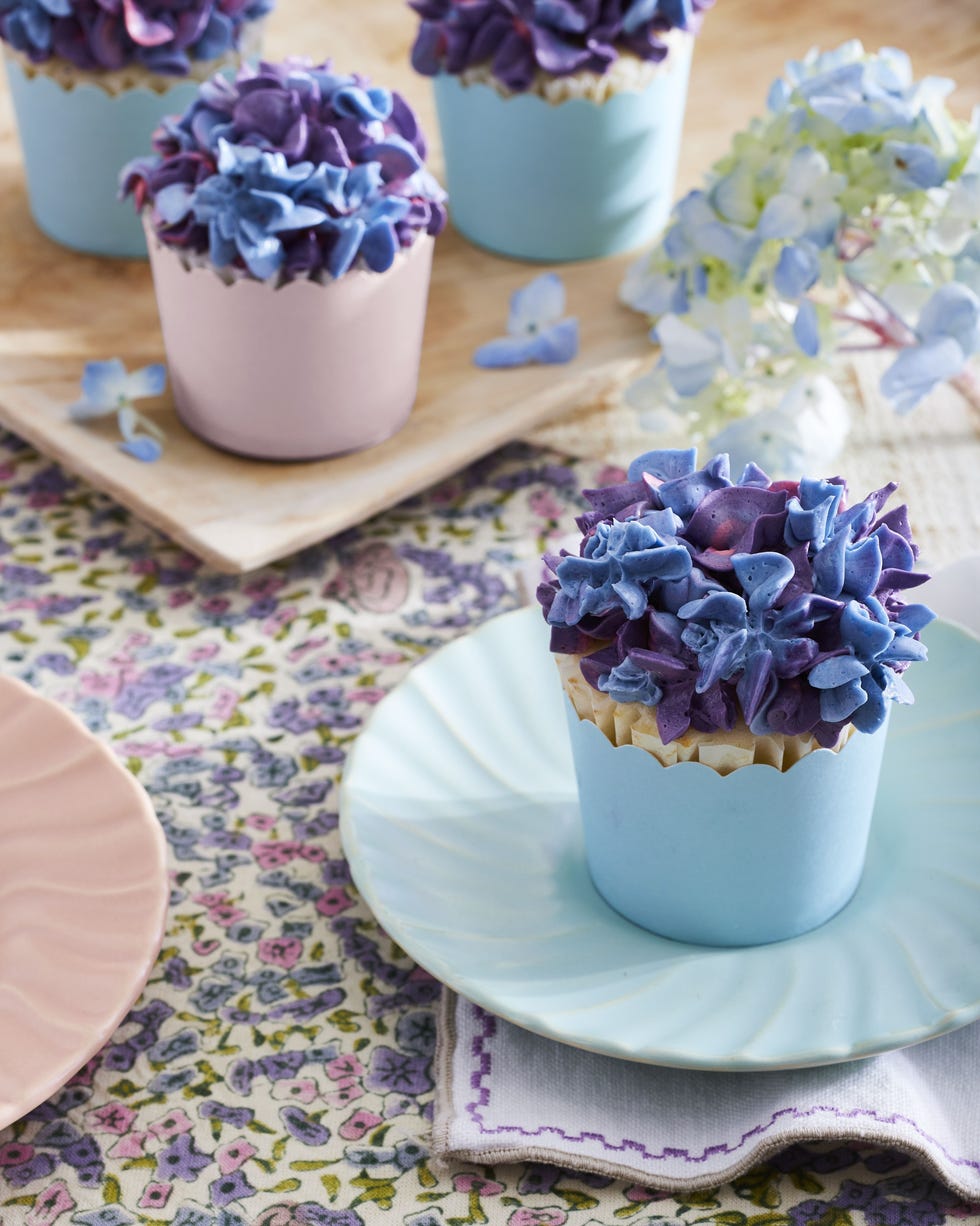 buttermilk lime cupcakes in pink and blue pastel liners with swiss meringue buttercream piped on top to look like lilacs