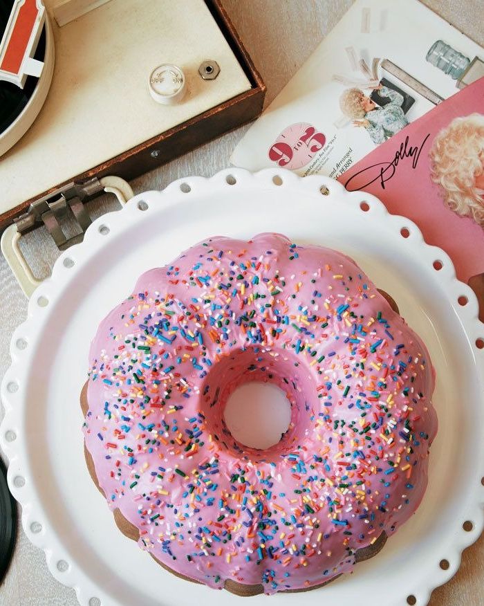 dollys donut coconut bundt cake with pink glaze and sprinkles